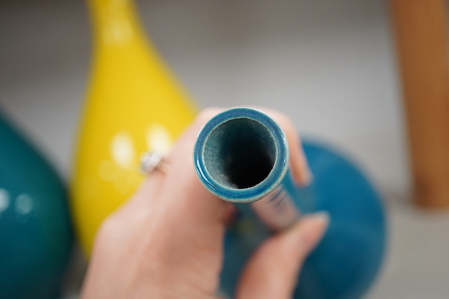 A late 19th century Japanese turquoise glazed narrow neck bottle vase, 31cm high, a smaller similar vase, 22cm high and a tall yellow glazed vase, 31cm high. Condition - repair to neck of yellow vase